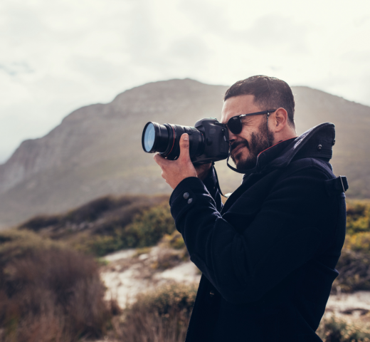 mężczyzna wykonujący fotografie w podróży, fotograf i podróżnik, sposoby na podróżnicze fotografie