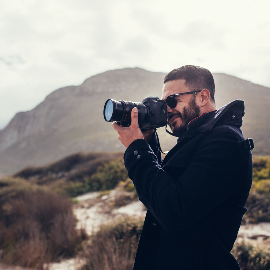 mężczyzna wykonujący fotografie w podróży, fotograf i podróżnik, sposoby na podróżnicze fotografie