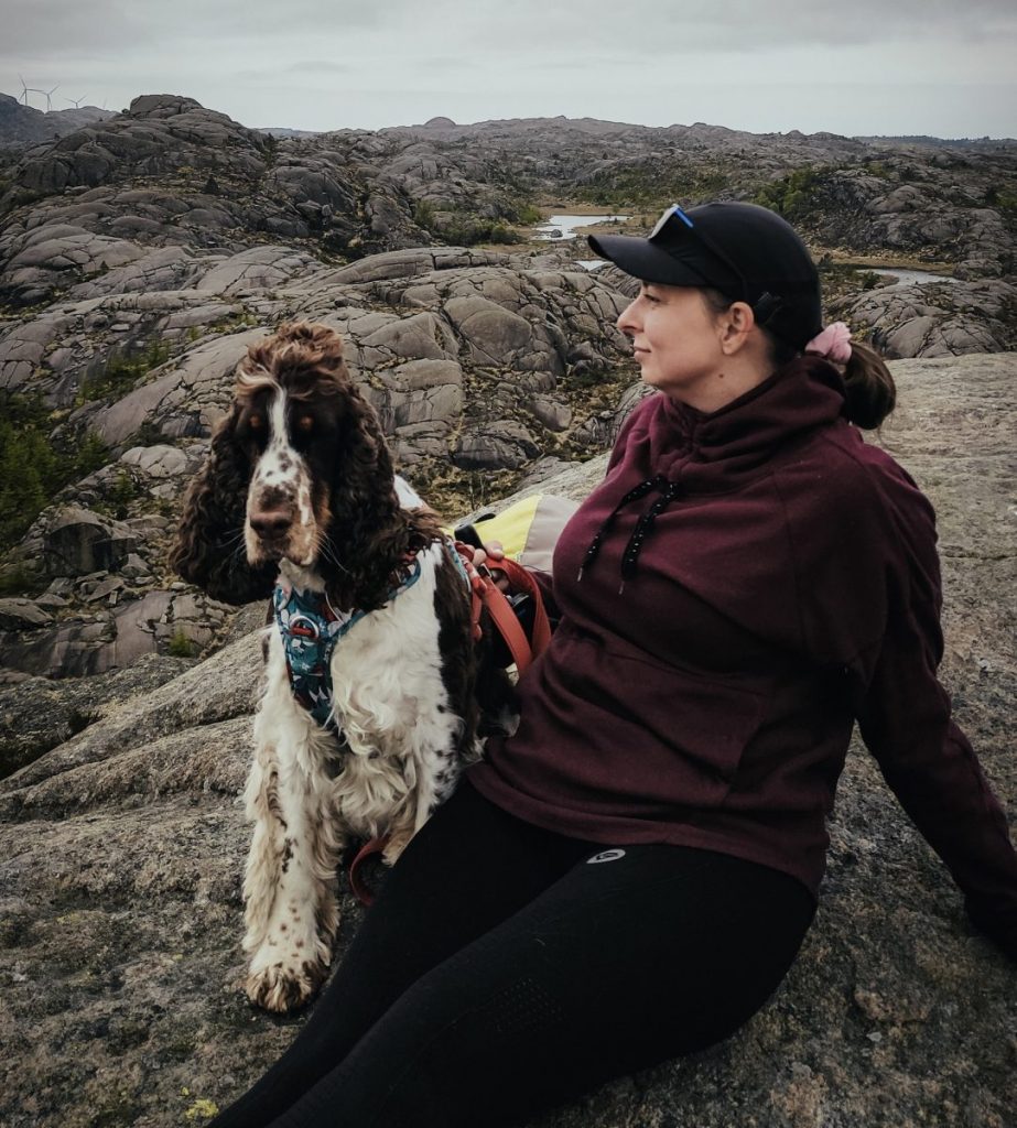 kobieta z psem na górzystym terenie